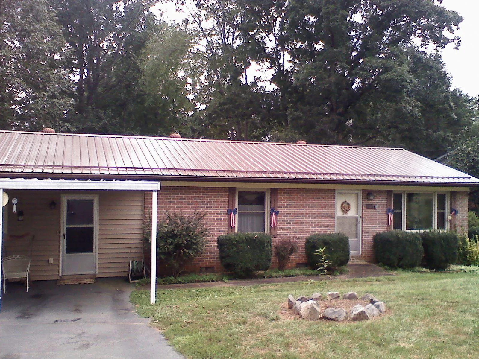 Bronze metal roof and carport on a brick ranch home — Roof Repair work by our crew in Leesburg